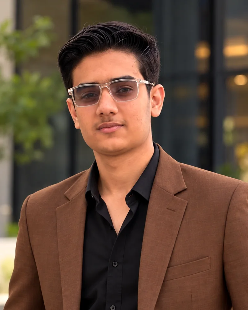 Ahmad Hassan Ismail, GTM engineer, photographed outdoors in a brown blazer